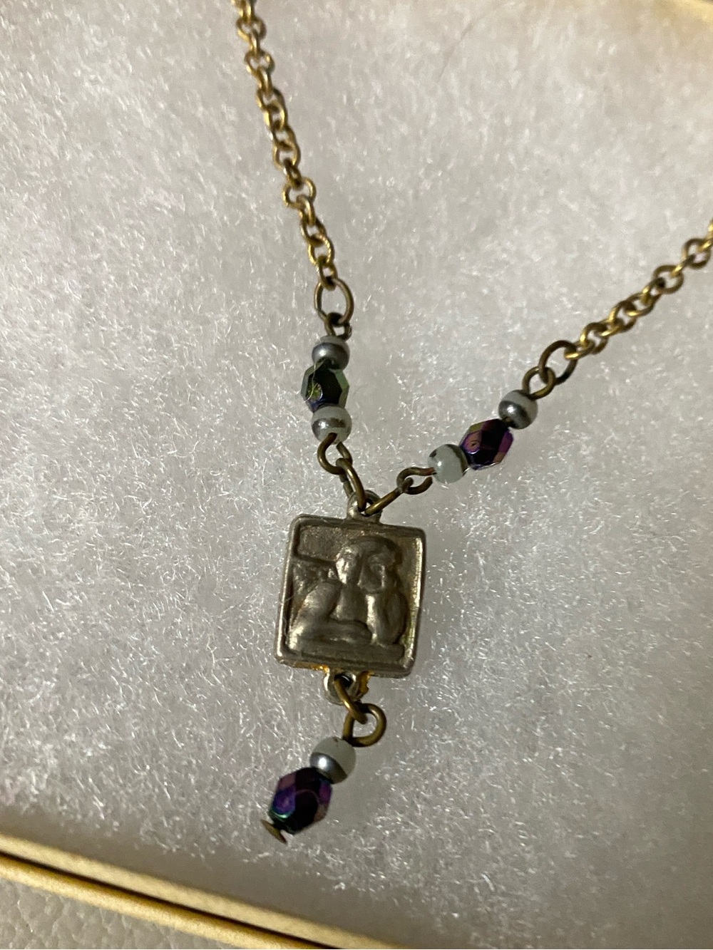 Gold-Tone square pendant Necklace with cherub and iridenscet Purple Beads